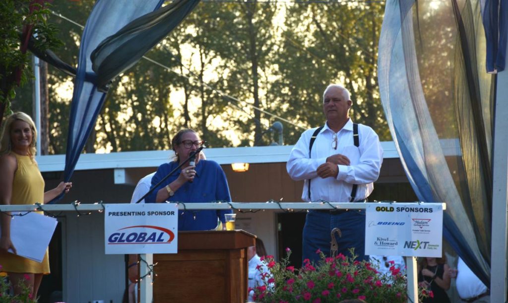 Event sponsors on an outdoor stage at the Columbia Learning Center Scholarship fundraiser in Oregon.